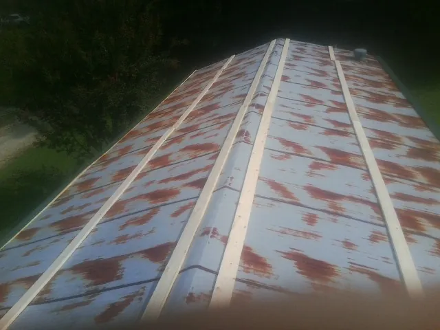 Rusted metal roof panels with new wood purlins before replacement — Storm Damage Roof Repair in Blairsville by Roofing Brothers